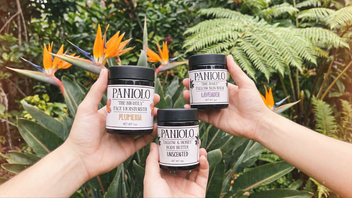 Three Paniolo jars held up in front of bird of paradise flowers